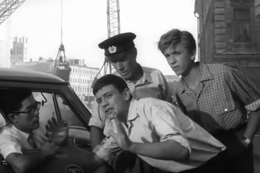Чёрно-белый кадр из советского фильма, молодые герои на московской улице у автомобиля